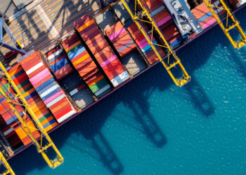 Metizoft to provide Strategic Marine Group with ESG application service, MTB Events, image shows aerial view of a cargo ship container harbour with colourful containers and bright blue sea