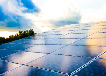 SUSI Partners holds final close for Southeast Asia Energy Transition Fund, SAETF, MTB Events, image shows rows of solar panels in the foreground, background has silhouettes of trees against the sunset