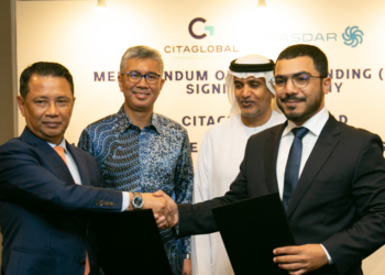Masdar & Citiglobal Berhand sign MoU to develop renewable energy across Malaysia, MTB Events. Image shows Abdulla Zayed and Tan Sri (Dr) Mohamad Norza Zakaria shaking hands in front of Yang Berhormat Mulia Datuk Seri Utama Tengku Zafrul Aziz HE Khalid Ghanim Mohammed Alghaith. In the background there is a large poster with Citigroup and Masdar logos.