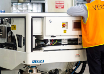 Strategic Marine & VEEM sign gyrostabilizer exclusivity agreement, MTB Events. Image shows a man in a florescent orange jacket with 'VEEM' on the back, looking over a gyrostabilizer