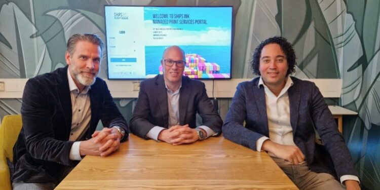 Ships Ink. & MPS Monitor Srl. announce exciting global maritime printing partnership, MTB events, Image shows from left to right: Ard Schalkwijk, Global Operations Manager at Ships Ink., Mark Kouwenberg, Sales Director at MPS Monitor Srl and Bart Mennega, Global Sales Manager at Ships Ink. All involved are at a wooden desk in front of a tv screen.