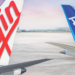 Expanded partnership between Virgin Australia & ANA offers even more benefits for passengers, MTB Events. Image shows two tails of two planes, one with the text 'Virgin' in red like the logo, the other is blue with 'ANA' in white text. Both are on tarmac at sunrise.