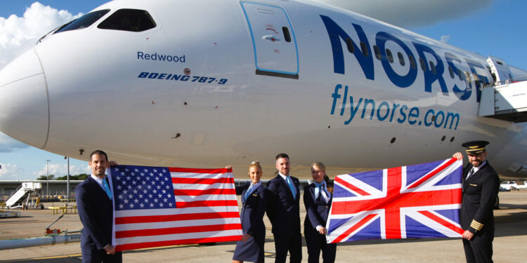 Norse Atlantic celebrates inaugural flights to LAX & SFO, MTB Events, Image shows Boeing 787 dreamliner on the runway with 5 Norse Atlantic Airways crew members, two holding a union jack and two holding the flag of the United States