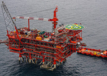 Reliance & bp begin production in India's KG D6 block, MTB events, image shows an aerial view of the KG basin with a red structure, the sea is a sark grey blue