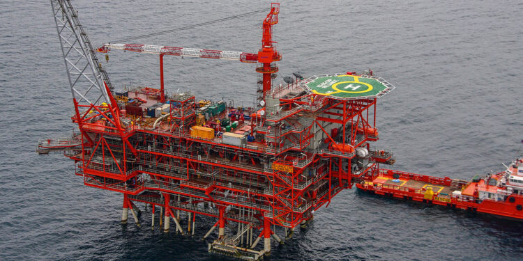 Reliance & bp begin production in India's KG D6 block, MTB events, image shows an aerial view of the KG basin with a red structure, the sea is a sark grey blue