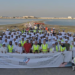 Bapco Energies continues their modernisation project with mangrove plantation & beach clean up, MTB Events. Image shows participants of the clean up on the Ma'ameer shore holding a large sign with the title 'World Mangrove Day 2023'.