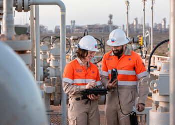 Chevron announces large scale acquisition of Hess, MTB Events. Image shows two Chevron technicians on site an emissions reduction system