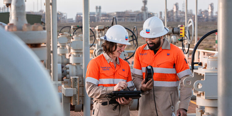 Chevron announces large scale acquisition of Hess, MTB Events. Image shows two Chevron technicians on site an emissions reduction system