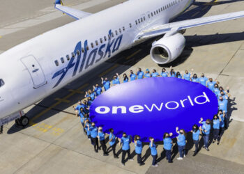 Senior VP for Alaska Airlines to be new CEO of the oneworld® alliance, MTB Events. Image shows Alaska Airlines plane on tarmac with a circle of people holding a large oneworld alliance logo