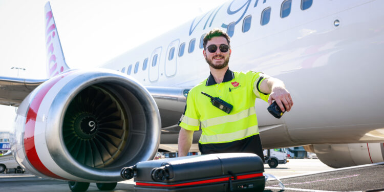 Significant expansion to Virgin Australia's revolutionary bag tracking tool, MTB Events. Image shows baggage handler scanning a bag outside a Virgin Australia bag