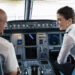 Wizz Air invest over 38 million euros into new pilots, MTB Events. Image shows two Wizz Air pilots in the cockpit of a plane smiling.
