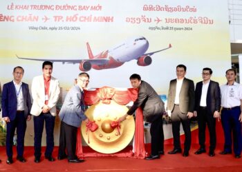 Vietjet celebrate new connections between Ho Chi Minh City with Vientiane, MTB Events. Image shows the ceremony with members of both airlines and cultural representatives of both countries banging a dong in front of a large Vietjet promotional image