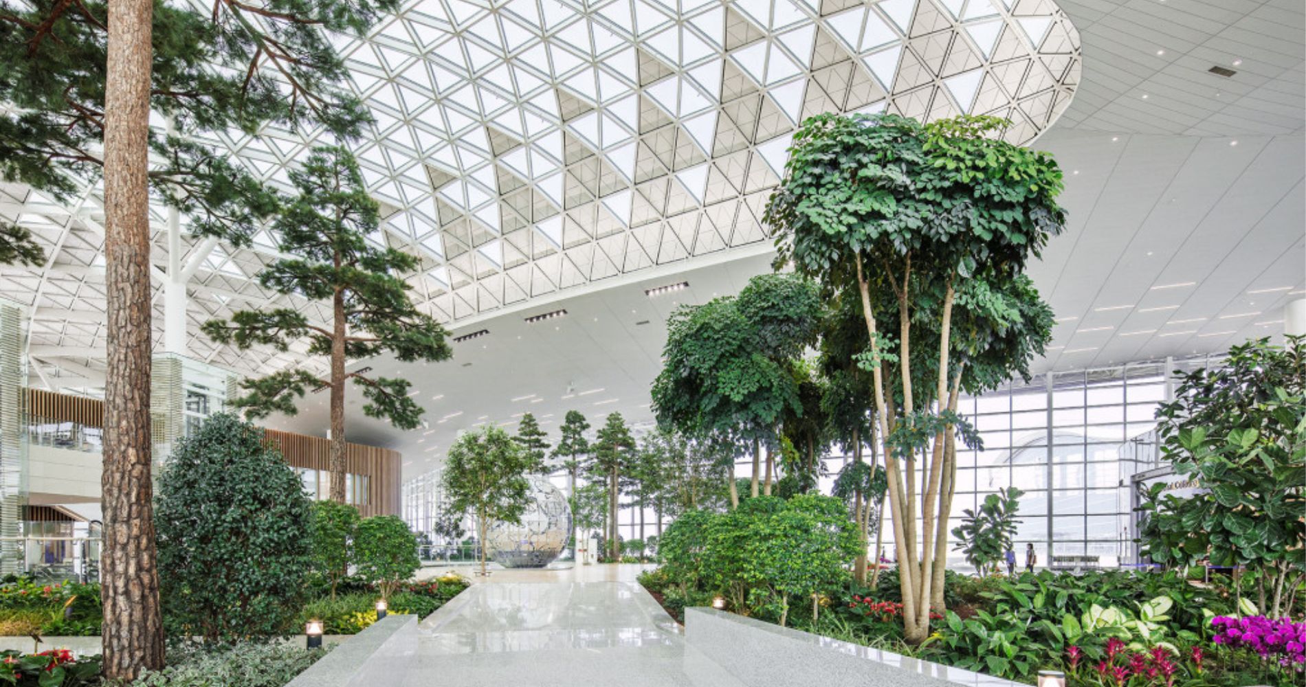 8 of the most beautiful airports in the world, MTB Events. Image shows the inside of Incheon Airport with trees and plants and marble flooring