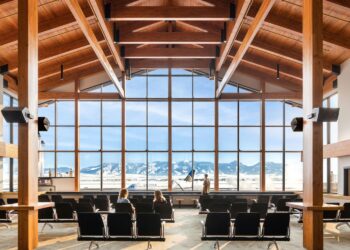 8 of the most beautiful airports in the world, MTB Events. Image shows the inside of Bozeman Yellowstone Airport, the view of the Bridger Mountain Range from a large window