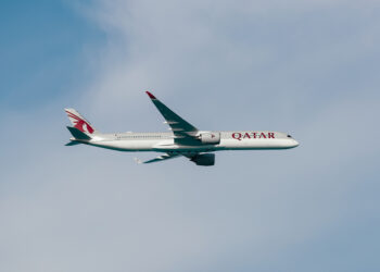 Image shows a Qatar Airways flight in the sky with thin clouds behind the plane. Qatar Airways Expands Flight Frequencies to More Than 15 Destinations, MTB Events.