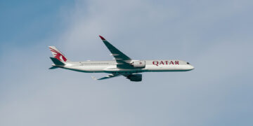 Image shows a Qatar Airways flight in the sky with thin clouds behind the plane. Qatar Airways Expands Flight Frequencies to More Than 15 Destinations, MTB Events.