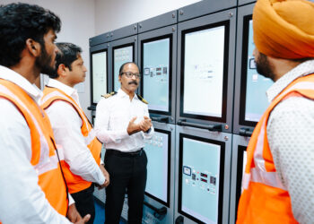 Image shows 4 men in orange jackets - Seafarer training on alternative fuels: the new methanol bunkering simulator from Wärtisä at BSM's Maritime Training Centre in Kochi ©BSM. BSM Unveils First Methanol Bunkering Simulator at Kochi Training Centre in Collaboration with Wärtsilä, MTB Events.