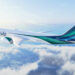 Image shows an Alaska Airlines plane with green and blue stripes on the fuselage flying in the sky with clouds below. Alaska Airlines Expands International Reach with New Routes to London and Reykjavik, MTB Events.