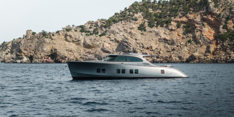 Image shows the superyacht titled Loloma on the sea with a backdrop off a cliffside. Zeelander Yachts Delivers Custom Zeelander 7, Loloma, MTB Events.