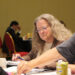 Image shows a man and a woman side on towards the camera pointing at a document on a table, with another woman in the foreground. From Meetings to Memories: Reflecting on MTB Aviation Europe 2025, MTB Events.