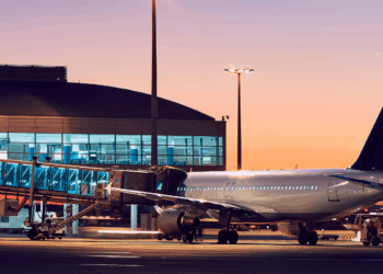 Image shows an airplane being prepared to be boarded at an airport with an orange sky in the background. ACI Unveils Roadmap for Smarter Airport Partnerships, MTB Events.