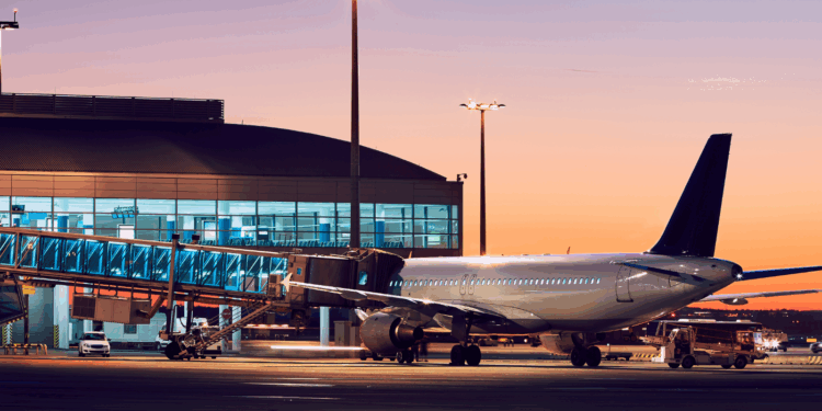 Image shows an airplane being prepared to be boarded at an airport with an orange sky in the background. ACI Unveils Roadmap for Smarter Airport Partnerships, MTB Events.