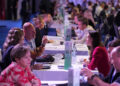 Image shows white tables going vertically along a hall with people sat either side in a room lit with blue and pink lights. Connections, Collaboration and Community was the theme of this year’s MTB Marine Europe , MTB Events.