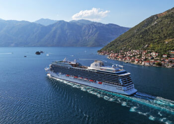 Image shows the cruise ship sailing on a large river between two mountains. Oceania Allura Sets a New Benchmark in Marine Luxury Design, MTB Events.
