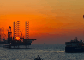 Image shows an oil rig and vessel at sunset with a colourful sky. BLÜCHER Strengthens Support for Greek and Cypriot Marine Markets Through Partnership with OCEANDYNAMIC, MTB Events.