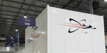 Image shows inside a warehouse building with a large white wall with the text Flight Power, alongside their logo. A Visit to Flight Power’s Plant 98 — Reflections from Holly, MTB Events, MTB Events.