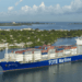 Image shows a container vessel with the text 'TOTE Maritime' down the side. Two Tugboats are in front and behind the vessel. New LNG Bunkering Agreement Supports U.S. Maritime Fuel Transition, MTB Events.