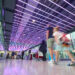 Summer Activities - July 2024. Passengers at London Heathrow Airport in part of terminal with coloured ceiling lights. Record-Breaking Start to 2026 for Heathrow, MTB Events.