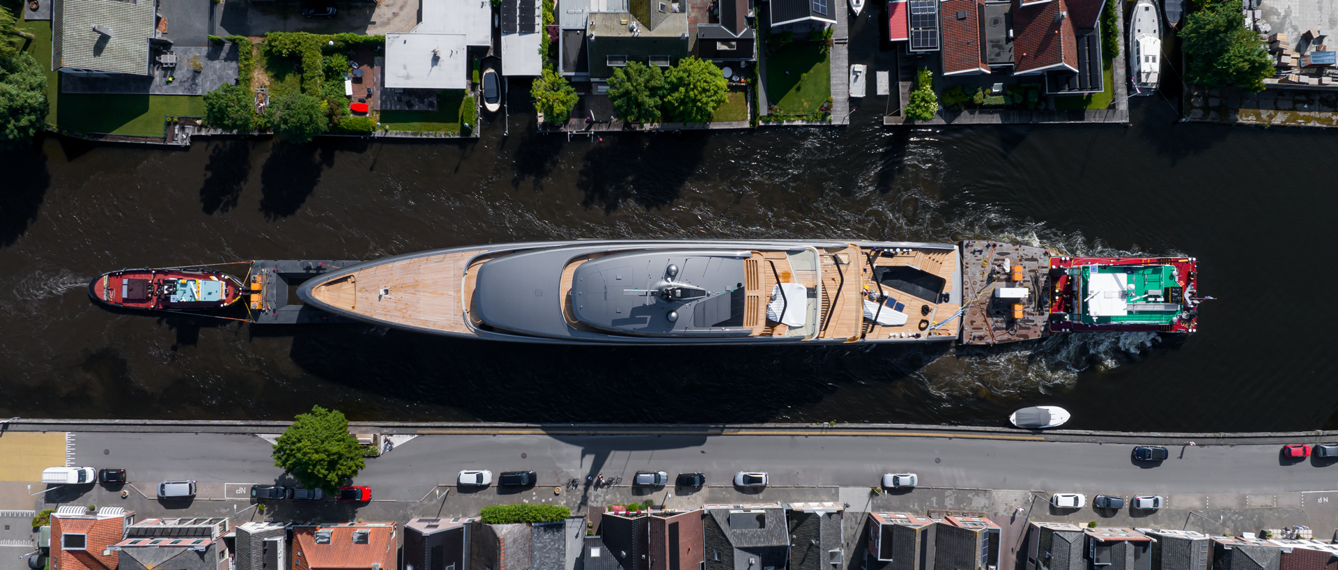 Feadship's Obsidian sets a higher standard for carbon reduction, MTB Events, Image shows the superyacht, 'Obsidian' sailing down a canal between two rows of houses